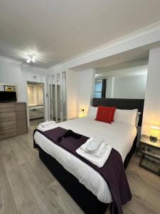 um quarto com uma cama grande e uma almofada vermelha em Chiltern Street Serviced Apartments - Marylebone em Londres