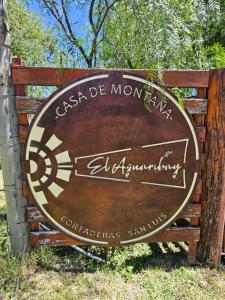 een bord op een houten bank in het gras bij El Aguaribay casa de montaña in Cortaderas