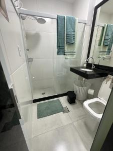 y baño con ducha, aseo y lavamanos. en Acolhedor apartamento na quadra da praia, en Río de Janeiro