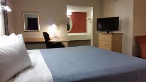 a hotel room with a bed and a television at Days Inn by Wyndham Buena Park in Buena Park