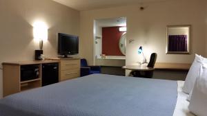 a hotel room with a bed and a television at Days Inn by Wyndham Buena Park in Buena Park