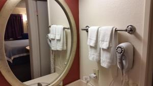 a bathroom with a mirror and white towels at Days Inn by Wyndham Buena Park in Buena Park