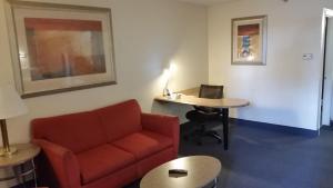 a living room with a red couch and a desk at Days Inn by Wyndham Buena Park in Buena Park