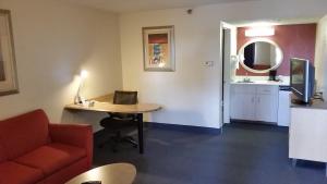 a room with a couch and a table and a mirror at Days Inn by Wyndham Buena Park in Buena Park