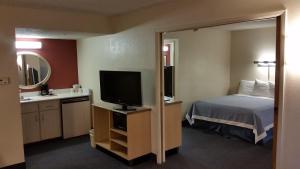 a hotel room with a bed and a television at Days Inn by Wyndham Buena Park in Buena Park