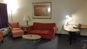 a hotel room with a couch and chairs and a table at Days Inn by Wyndham Buena Park in Buena Park