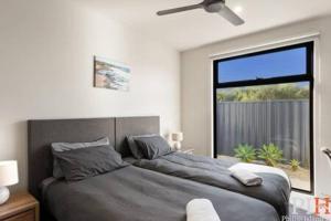 a bedroom with a large bed and a large window at Luxurious Home Close to The Beach in Surf Beach