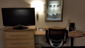 a television sitting on a desk in a hotel room at Days Inn by Wyndham Buena Park in Buena Park