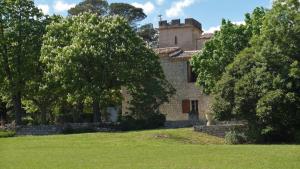 an old stone house with trees in a field at Domaine de Monteils in Carnas