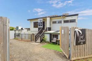 Casa con valla de madera y puerta en 2-Person Surf Beach Studio App, en Surf Beach
