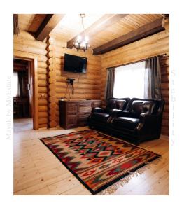 a living room with a leather couch and a television at Mayak Chalet Resort Mykulychyn in Mykulychyn
