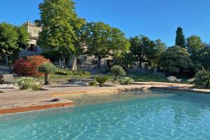a swimming pool in a yard with trees and a building at Domaine de Monteils in Carnas