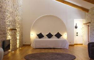 a bedroom with a white bed with an archway at Domaine de Monteils in Carnas +78 photos