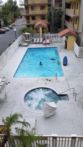 a pool with two people swimming in it at Days Inn by Wyndham Buena Park in Buena Park
