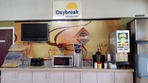 a counter with a microwave and a tv on a wall at Days Inn by Wyndham Buena Park in Buena Park