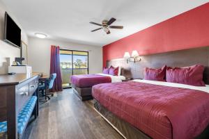 a hotel room with two beds and a ceiling fan at Bay Breeze Inn in Seaside