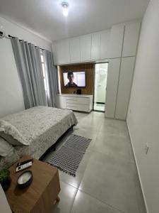 - une chambre avec un lit et une télévision dans l'établissement Acolhedor apartamento na quadra da praia, à Rio de Janeiro