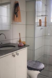 uma casa de banho com um chuveiro, um WC e um lavatório. em Apartamento de Praia em Florianópolis