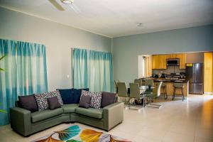 a living room with a couch and a dining room at Beautiful Village 3 bedrooms Furnished Pool residencial Velero punta cana in Punta Cana