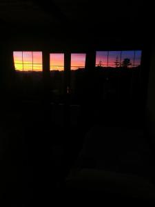 una puesta de sol vista a través de las ventanas de un edificio en Chambre La Séquoiane Col de Turini, 