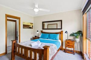 een slaapkamer met een groot bed met blauwe kussens bij Private Family Home Near North-Facing Beach in Cowes
