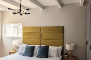 1 dormitorio con 1 cama con almohadas azules y blancas en Beachside Bliss Oceanview Apt in Manhattan Beach, en Manhattan Beach