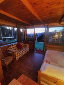 Habitación con cama, sofá y ventanas. en Chambre La Séquoiane Col de Turini, 