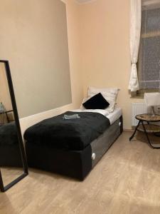 ein Schlafzimmer mit einem Bett mit einer schwarzen Decke darauf in der Unterkunft Adam's Pension in Chemnitz