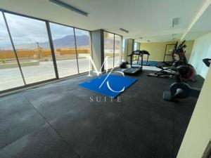 a gym with exercise equipment in a room with windows at MC Suite Norte in Antofagasta