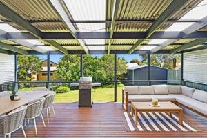 a patio with a couch and tables and chairs at Kookaburra Hideaway 4-Bed 2-Bath in Cowes