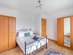 a bedroom with a bed and a dresser and a mirror at Ty Cwtch in Seven Sisters