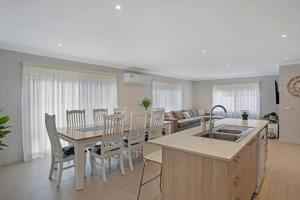 eine Küche und ein Wohnzimmer mit einem Tisch und Stühlen in der Unterkunft Private Luxury Home in Quiet Cowes Estate in Cowes