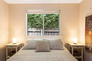 ein Schlafzimmer mit einem Bett und einem Fenster mit zwei Tischen in der Unterkunft Private Luxury Home in Quiet Cowes Estate in Cowes
