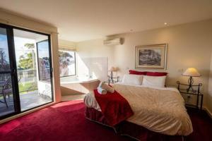 a bedroom with a large bed and a large window at Moonlight Bay and Gallery Ocean View King Suite #3 in Newhaven