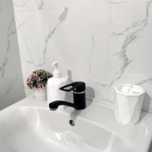 lavabo con dispensador de jabón en Квартира Rose, en Öskemen