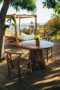 a table and chairs on a patio with a bed at El Xalli Hotel in El Zonte