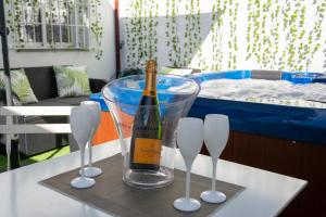 een fles champagne in een plastic container op een tafel bij Malaga Chic jacuzzi y playa in Málaga