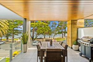 a patio with a table and chairs and a grill at Waterfront Apt Gorgeous Views in Cowes