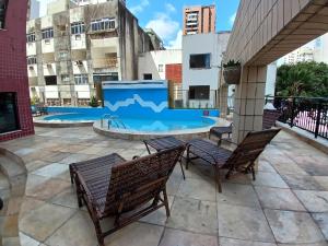 a patio with two chairs and a pool at Saint Martin By Escala Imóveis in Fortaleza