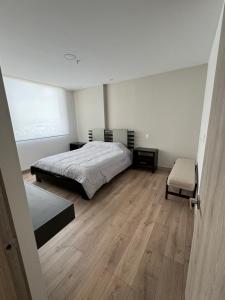 a bedroom with a bed and a chair in it at Urban Chic Departamento en la Shyris in Quito