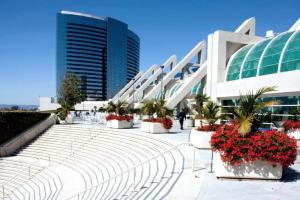 a large building with plants and flowers in front of it at Extraordinary Escape with Rooftop Pool 2 in San Diego