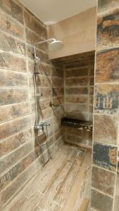 a shower in a bathroom with a stone wall at 5star apartment View of the Nile and the pyramids on the Nile Corniche in Cairo