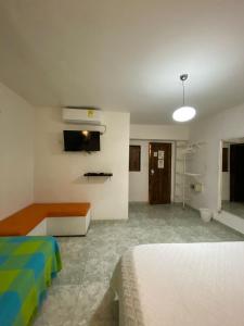 een slaapkamer met een bed en een kamer met een tv bij Patio de Getsemani in Cartagena