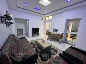 uma sala de estar com um sofá e uma mesa em Residence Lyne em Kairouan