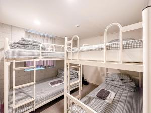 a room with three bunk beds in it at Dongseongro ZERO guesthouse in Daegu
