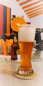 un vaso de cerveza sentado en una mesa con una rodaja de naranja en ᒍᑌᕼᗩᒪᑌ, en Jericó