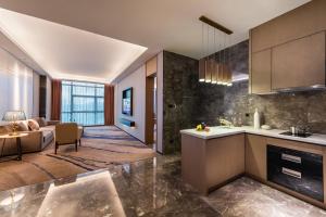 a kitchen and living room with a couch and a table at Mercure Shenzhen Pinghu in Shenzhen