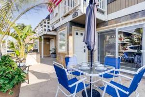 a table with chairs and an umbrella on a patio at AWESOME 3BR 1 Block To Ocean Fast WIFI C1 in Newport Beach
