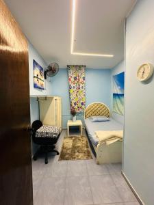 a small bedroom with a bed and a chair at Alis Villa in Hurghada