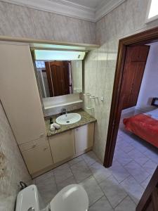 a bathroom with a sink and a mirror and a bed at TABAIBA REFUGIO DEL MAR in Santa Cruz de Tenerife